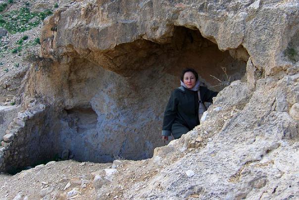 Global Family Chat additional slides.024.jpg - Dr Leslie Brooks, Mother of the Domain of Israel, stands in one of many caves at Marsaba Monastery where even now monks spend their days in silence.